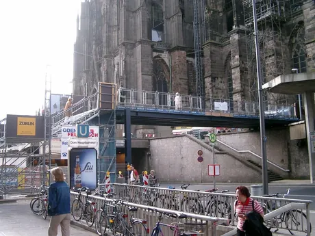 Gerüst mit Schutzdach über einem Gehweg am Kölner Dom
